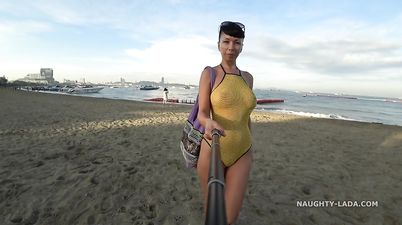 MILF exhibitionist in fishnet swimsuit outdoors on public beach